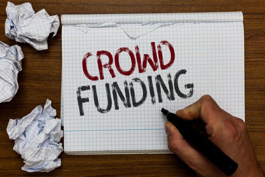 Handwriting text Crowd Funding. Concept meaning Fundraising Kickstarter Startup Pledge Platform Donations Man holding marker notebook crumpled papers ripped pages mistakes made.