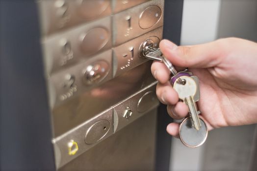 Elevator access control. hand holding a key to unlock elevator floor