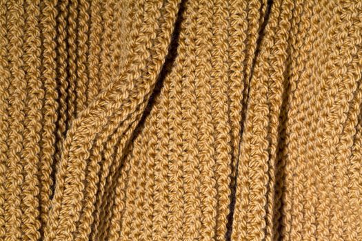 Yellow wool knitted scarf closeup.