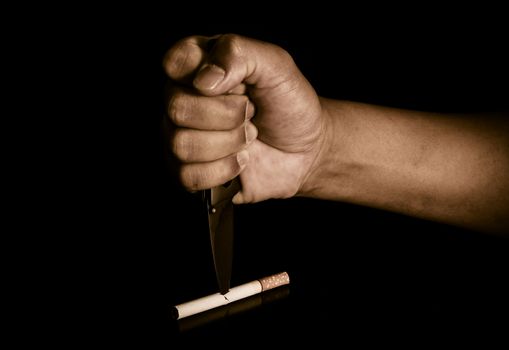 Handle knife stabbed into cigarettes concept eliminate smoking, quit smoking.