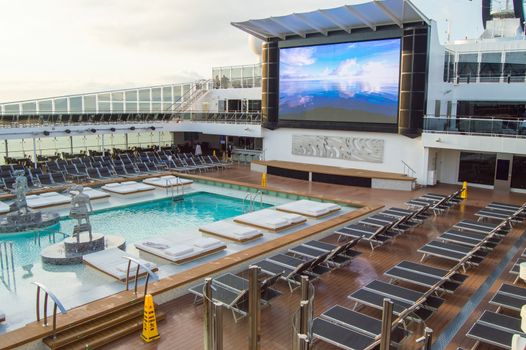 Outdoor deck with swimming pool, sun beds, video screen. CRUISE ship MSC Meraviglia, 8 October 2018.