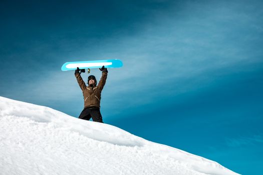 Happy man with snowboard in the mountains