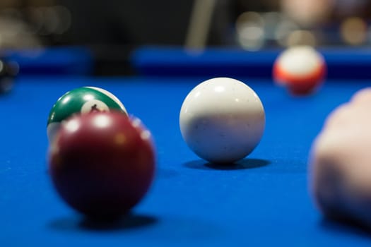 Billiard pool in progress, balls are on blue table cloth