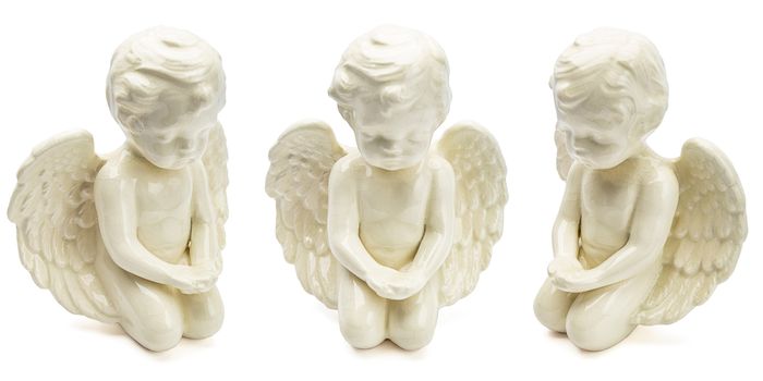 small figurine of white angel, kneeling with open wing