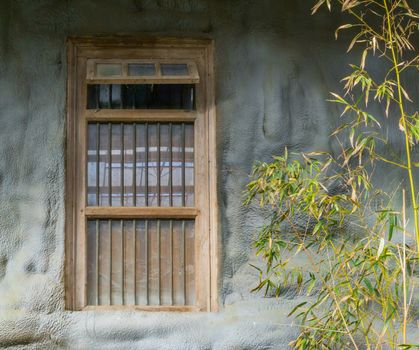 old dirty window framework with jail bars in a stone wall