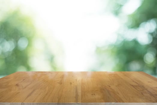 Empty wooden table in front of abstract blurred background of co