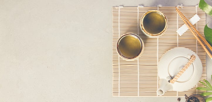 Asian food background - tea and chopsticks on a grey concrete background