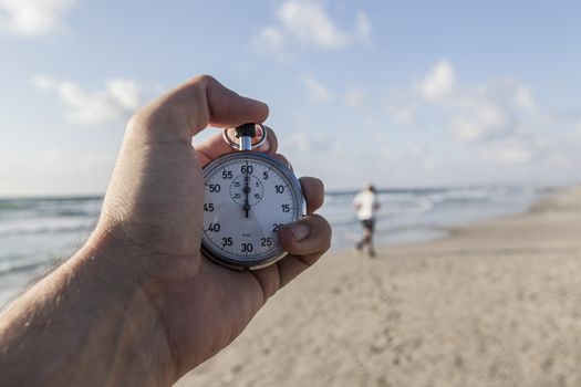 analog Stopwatch in hand with sea in the background