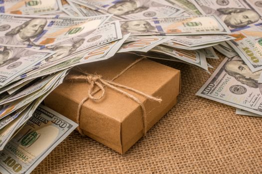 Gift box placed under  spread US dollar banknotes