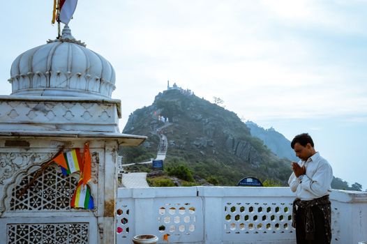 A jain pilgrim devotee meditating in front of famous historical Jainism Temple.