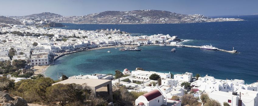panoramic view of the Mykonos town harbor with famous windmills 