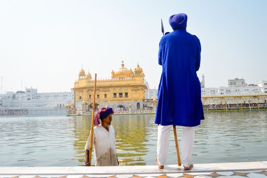 Amritsar, India - MAY 16: Unidentified Guard standing and looking around near "Sri Harmandir Sahib" or "Golden Temple" pond, in Amritsar, India. Golden Temple is the holiest Gurdwara of Sikhism