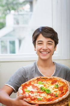 Happy teen boy cooked pizza