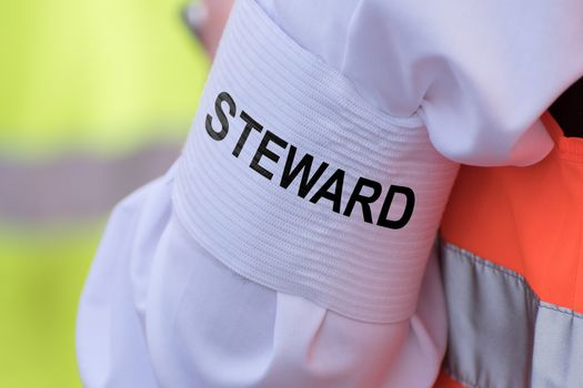 Detail of an armband with text "STEWARD"