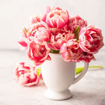 Bouquet of Spring tulips in vase on shabby chic background