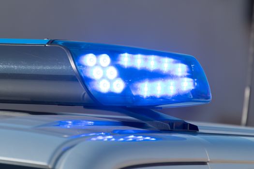 Detail shot of a glowing blue light on a police car