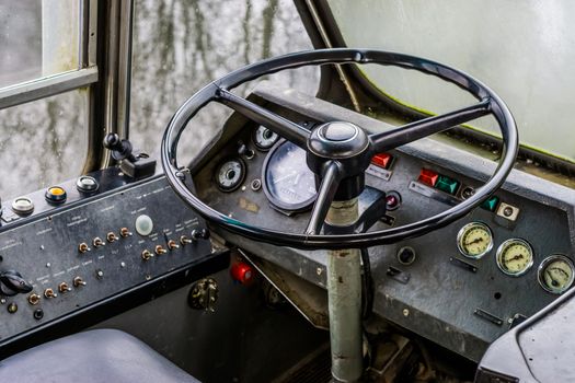 very old vintage interior of a old timer school bus, dashboard with steering wheel of a retro vehicle