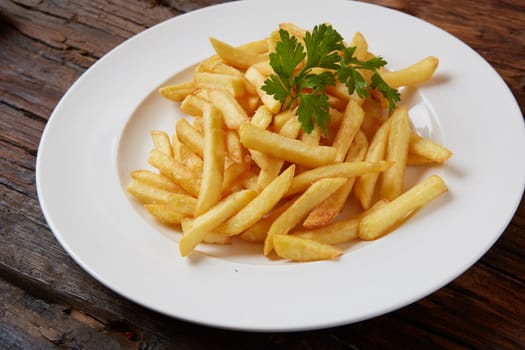 French fries in a bowl on a wooden background.