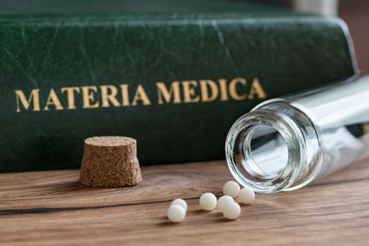 A bottle of homeopathic remedies with a materia medica
