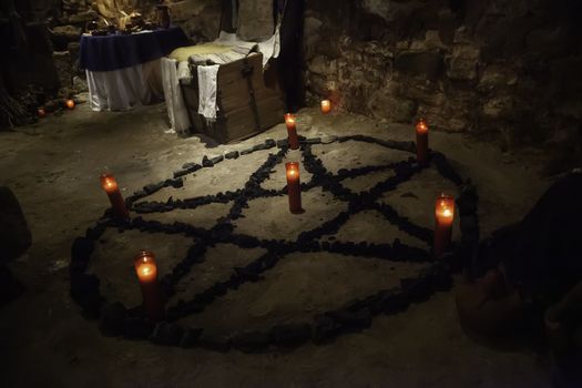 Satanic pentacle with lighted candles