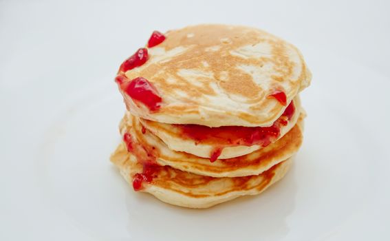 Pancakes with strawberry jam white plate. Selective focus
