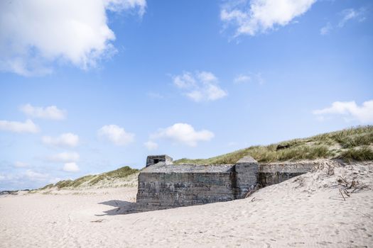 Dune on a beach with ruins of 2nd world war