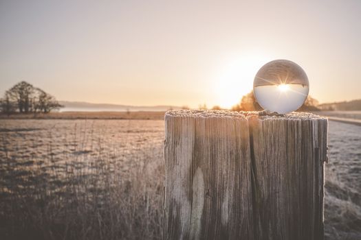 Winter sunrise with sun in a glass orb