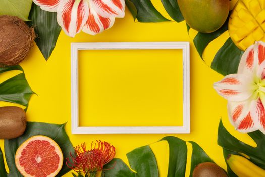 Creative flat lay with tropical fruits and plants and space for your text on yellow background