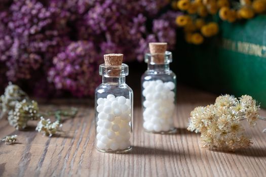 Bottles of homeopathic pills with dried herbs