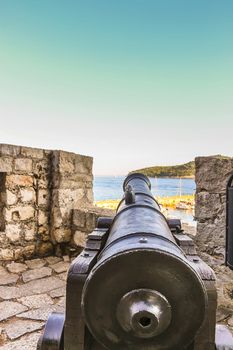 Aiming view of a cannon on the fortress of Dubrovnik City Walls with parts of Lokrum Island in the background