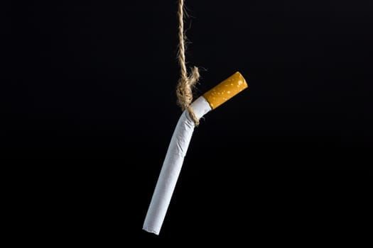 Anti Tobacco, Cigarette was hanged with a rope on dark backgroun