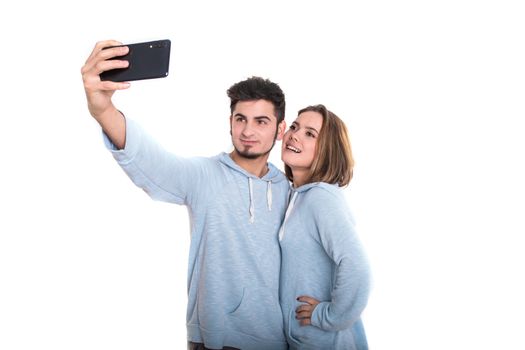 Young loving couple standing isolated on white and making selfie