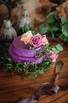 Violet wedding cake in rustical style with decorative flowers and vintage knife