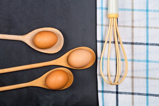 Eggs and kitchen utensil on backboard background.