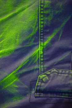 Ultraviolet pigment luminescence under UV light on cotton shorts. Luminescence is yellow-green colour and very vivid