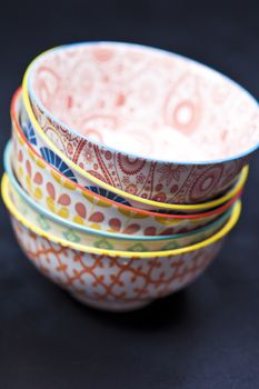 Stack of colorful empty ceramic bowls closeup.
