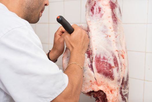 butcher cutting a large piece of meat