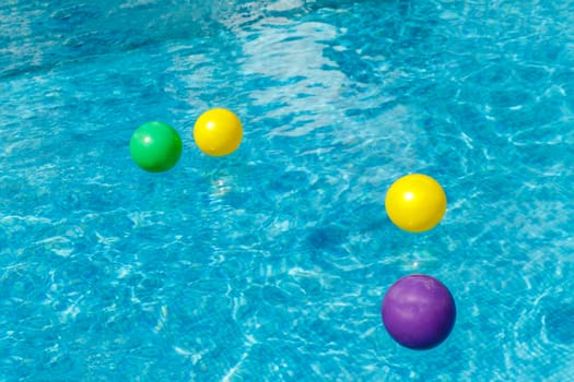 Inflatable water fun balls float on the water in the pool. Conce
