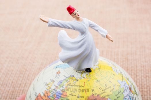 Swirling dervish on a globe on textured background