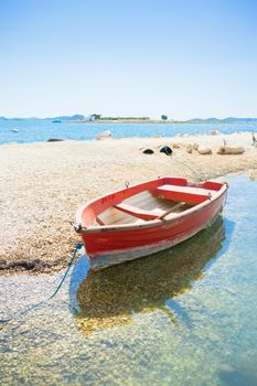 Pakostane, Croatia - A red rowing boat at the beach of Pakostane