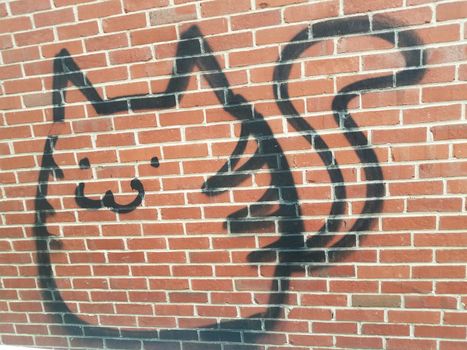 cat or animal graffiti vandalism on red brick wall