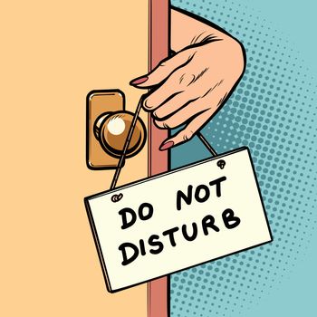 do not disturb woman hand hangs a sign on the door