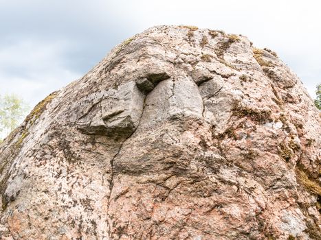 Someone's face on the surface of a large boulder