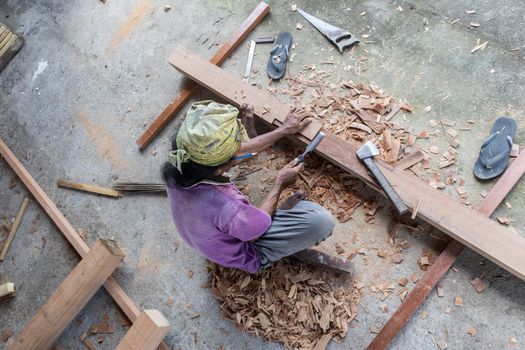Carpenter working in traditional manual carpentry shop in a third world country.
