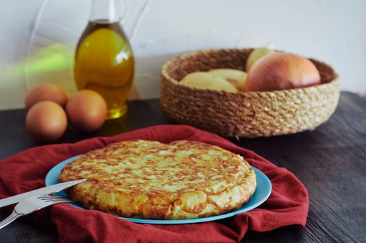 Spanish omelette with potato, egg and onion, accompanied by olive oil