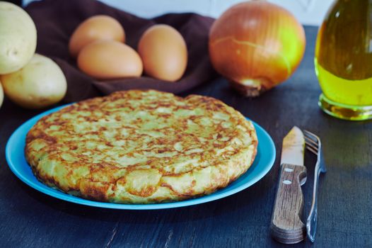 Spanish omelette with potato, egg and onion, accompanied by olive oil