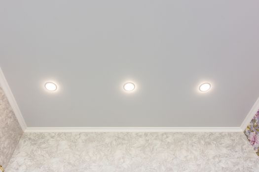 Three spotlights built into the suspended ceiling