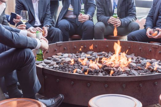 Businesspeople hangout near patio fire pit at wintertime in Chicago, America