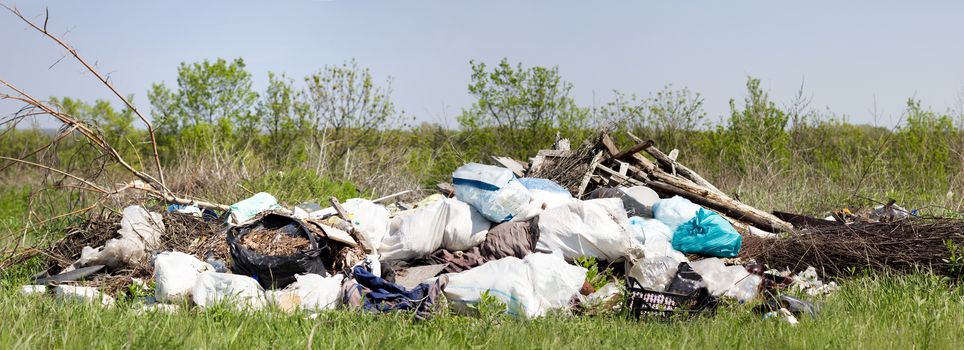 Panorama of a garbage dump in a field. Environmental pollution. 