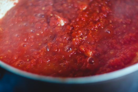 the process of cooking tomato marinara sauce in a saucepan